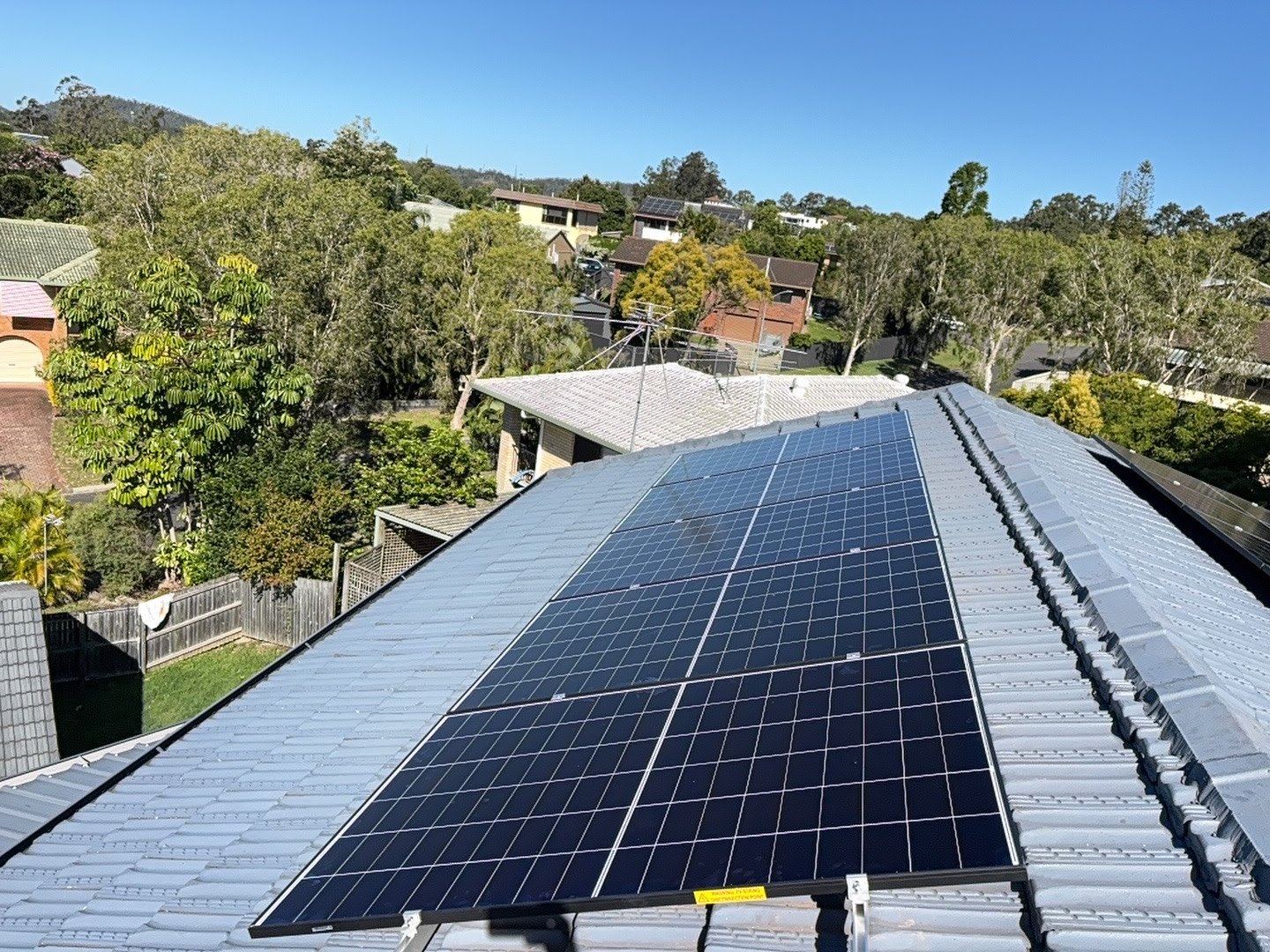 Solar array on a tiled roof, Sunshine Coast hinterland behind